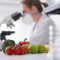 Scientist in lab with fruit and vegetables in foreground