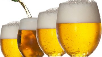 Pouring beer into four glasses with white background