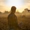 Farmer navigating drone above farmland
