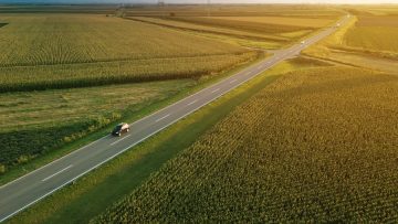 Aerial view of road through countryside and cultivated field