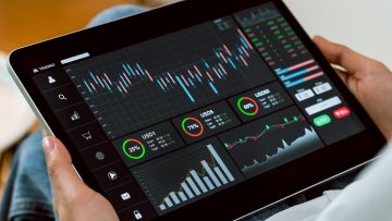 Stock exchange market concept, Hand trader touch on digital tablet with graphs analysis candle line on the table in house, diagrams on screen.