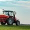Agricultural tractor fertilizing wheat crop field with NPK