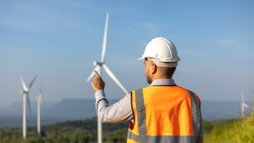 Engineer India man working with tablet at windmill farm Generati