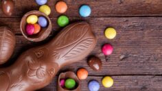 Chocolate easter eggs and sweets on wooden background