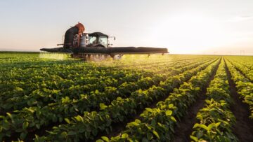 Tractor spraying pesticides at  soy bean field