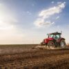 Tractor cultivating field at spring