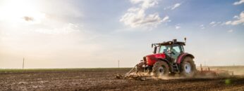 Tractor cultivating field at spring