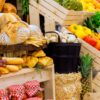 Vibrant farmers market display featuring fresh produce, baked goods in wooden crates