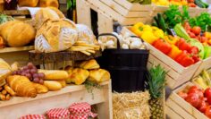 Vibrant farmers market display featuring fresh produce, baked goods in wooden crates