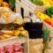 Vibrant farmers market display featuring fresh produce, baked goods in wooden crates
