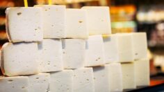 A stack of traditional Turkish white cheese, carefully arranged at a market stall. The soft, textured blocks are known for their creamy taste and rich dairy flavor.
