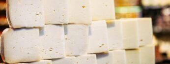 A stack of traditional Turkish white cheese, carefully arranged at a market stall. The soft, textured blocks are known for their creamy taste and rich dairy flavor.